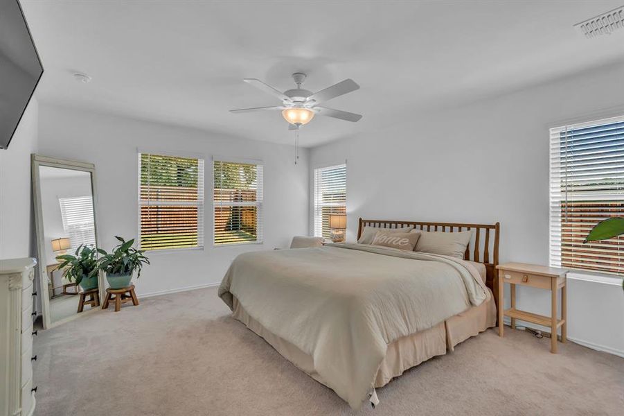 Carpeted bedroom featuring ceiling fan and baseboards