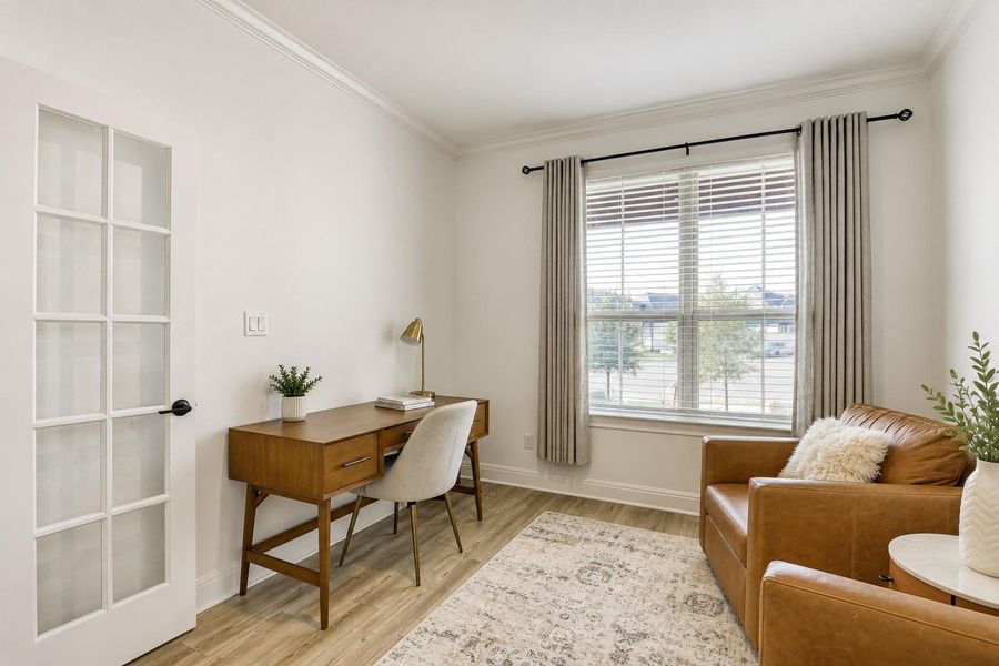 A versatile space features elegant french doors and crown molding, perfect for a home office or cozy den. A versatile space features elegant french doors and crown molding, perfect for a home office or cozy den.
