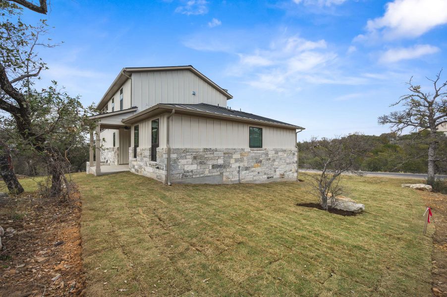 Exterior of home featuring upstairs balcony, stone, and durable board and batten style hardie-plank