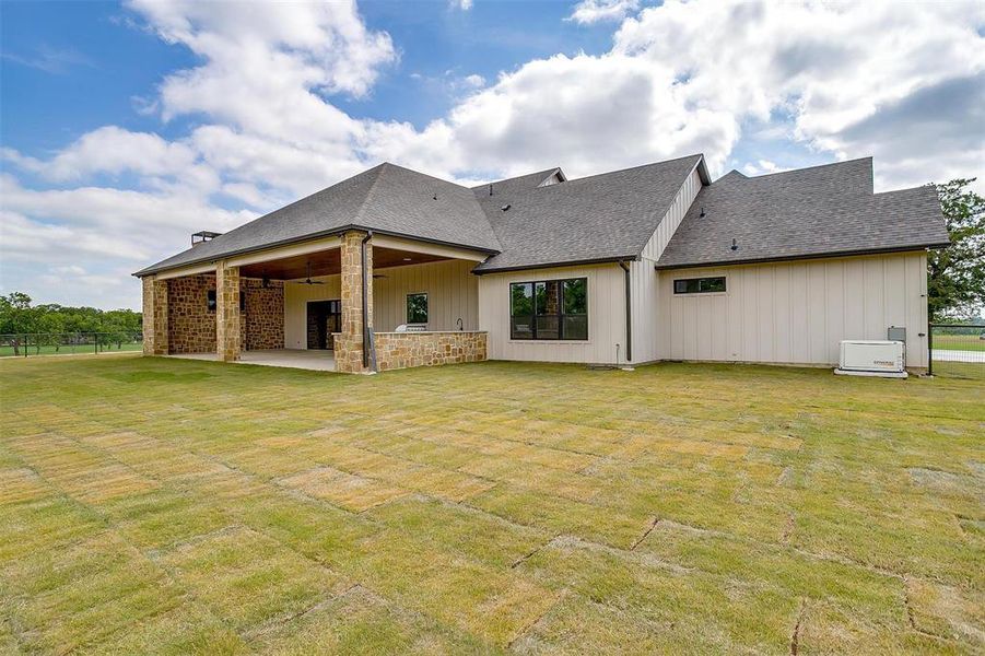 Rear view of property featuring a patio, ceiling fan, and a shingled roof Rear view of property featuring a patio, ceiling fan, and a shingled roof