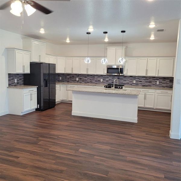 Kitchen featuring ceiling fan, backsplash, white cabinetry, and dark wood-type flooring