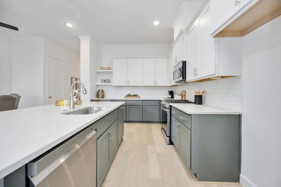 Designer Finishes Meet Everyday Function: Timeless meets trendy in this gourmet kitchen with Benedettini cabinets with soft-close drawers, quartz countertops, and custom design selections. The open layout keeps you connected to the living and dining spaces beyond.