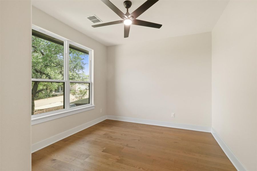 Empty room featuring light wood-type flooring, visible vents, ceiling fan, and baseboards Empty room featuring light wood-type flooring, visible vents, ceiling fan, and baseboards