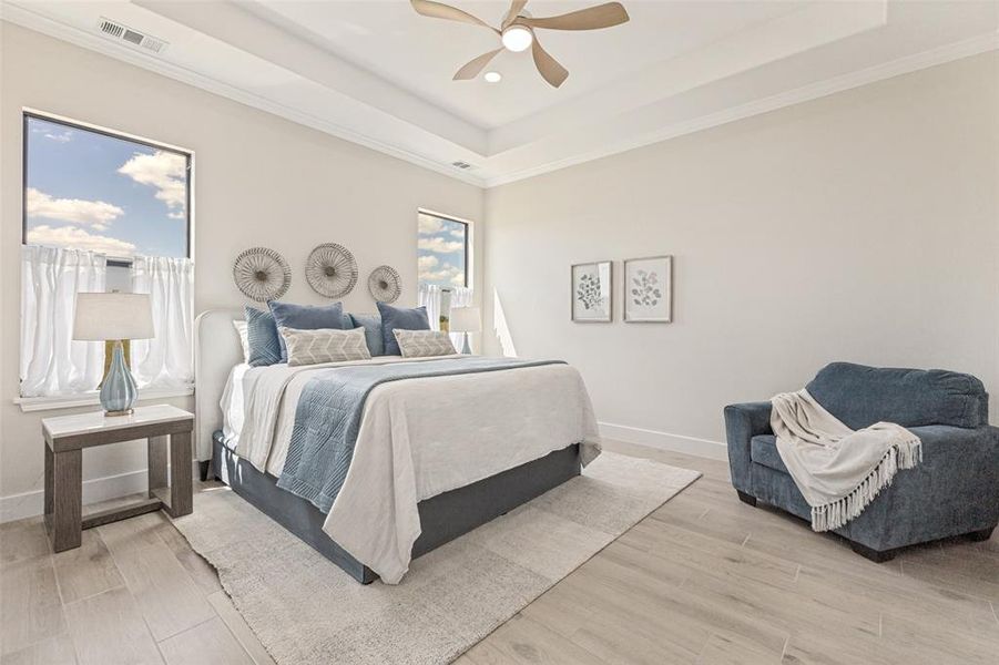 Primary bedroom featuring tray ceiling with crown molding, ceiling fan, and recessed lighting