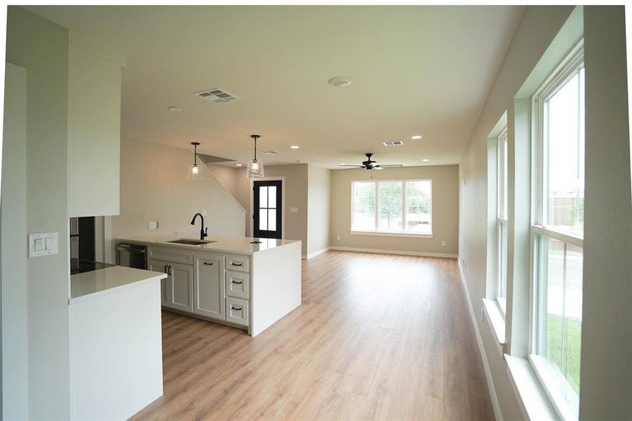 Kitchen featuring recessed lighting, white cabinetry, light wood-style floors, hanging light fixtures, and open floor plan