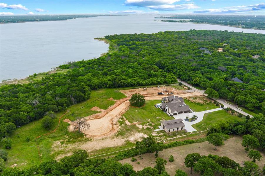 Expansive estate featuring a large main residence, a separate auxiliary building, a winding paved driveway, and mature landscaping Expansive estate featuring a large main residence, a separate auxiliary building, a winding paved driveway, and mature landscaping
