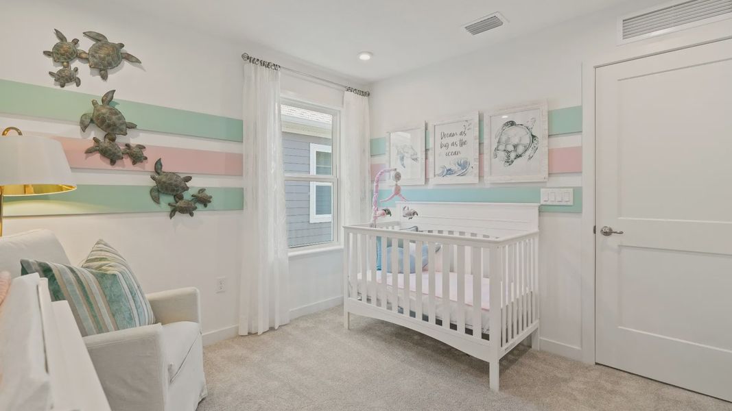 Carpeted secondary bedroom with large window in a DRB Homes Ambersweet model at the Trinity Place community. Carpeted secondary bedroom with large window in a DRB Homes Ambersweet model at the Trinity Place community.