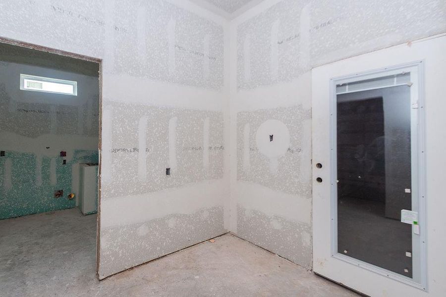 Spacious unfinished room with drywall installed, featuring a large glass door leading to another area, offering potential for customization and natural light. Spacious unfinished room with drywall installed, featuring a large glass door leading to another area, offering potential for customization and natural light.