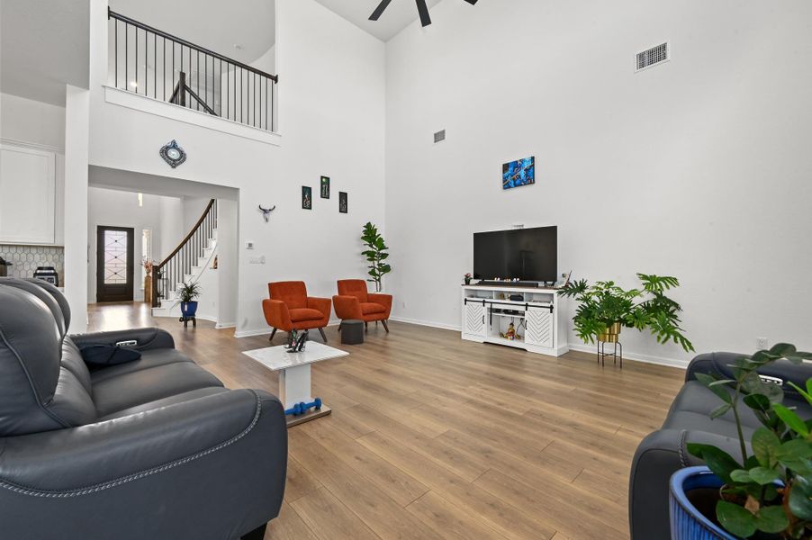 Warm wood flooring and soaring high ceilings define this open interior layout.