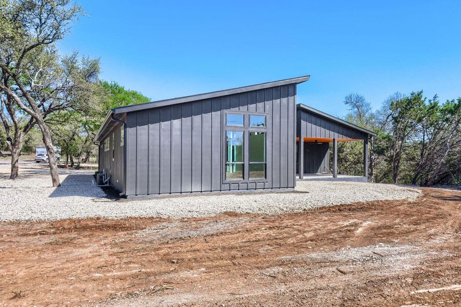 View of side of property featuring board and batten siding, a patio area, and a carport View of side of property featuring board and batten siding, a patio area, and a carport