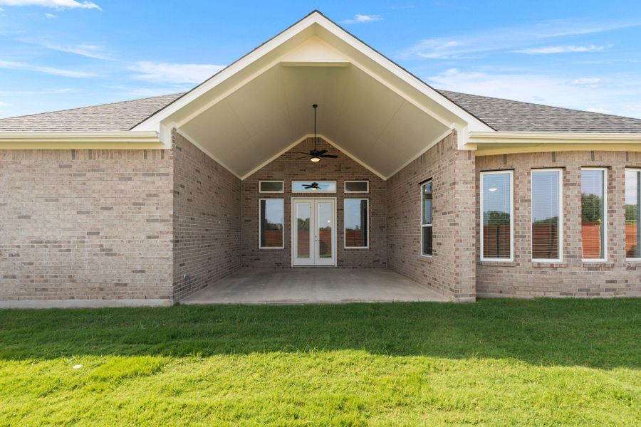 An inviting covered patio extends from this home's brick exterior, perfect for outdoor enjoyment.