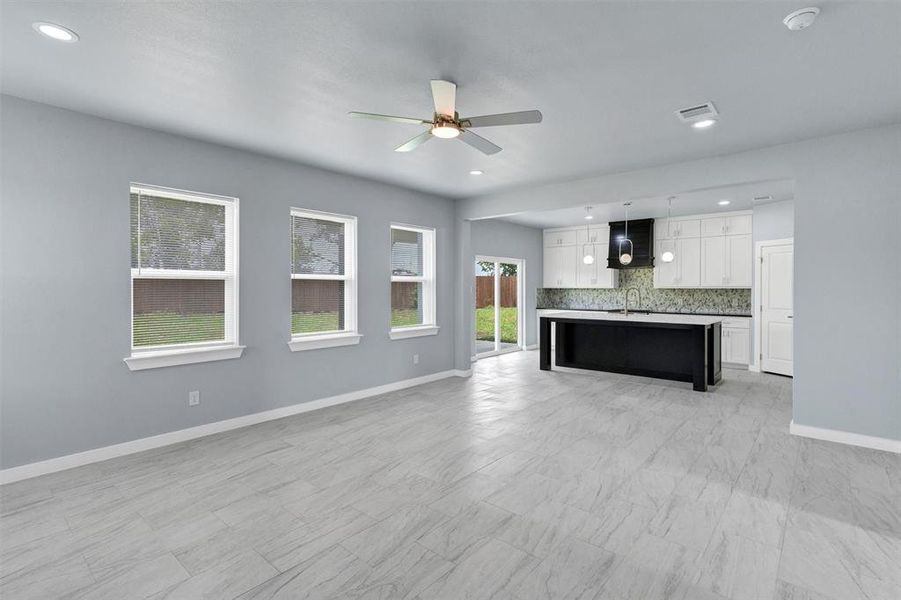 Unfurnished living room with ceiling fan and recessed lighting