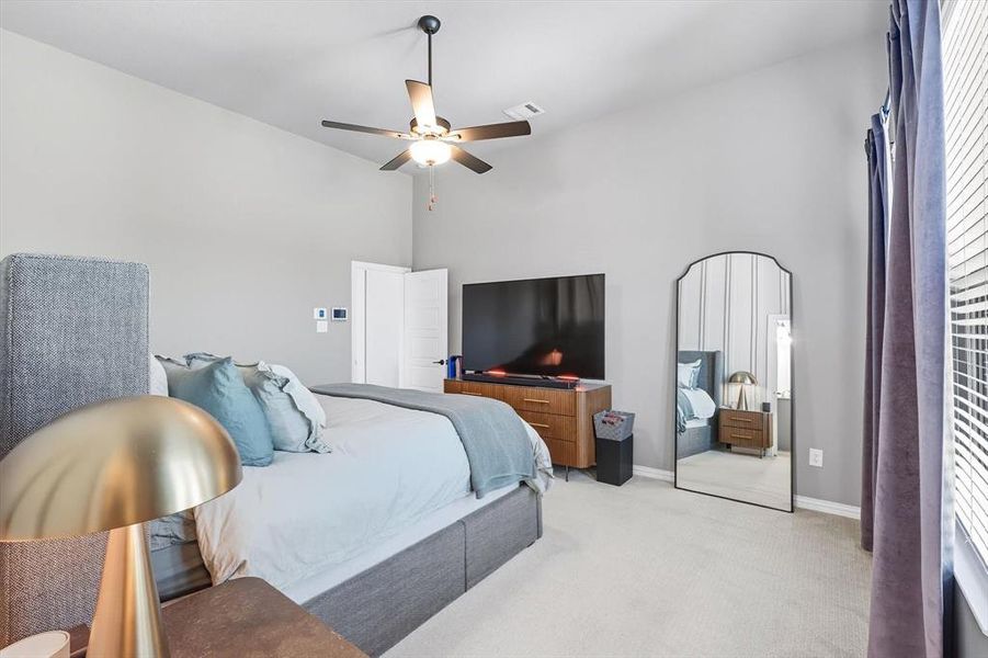 Carpeted bedroom featuring a ceiling fan and baseboards