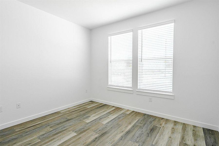 Natural light filters into this spacious room, featuring modern wood-look flooring and clean, minimalist design. Natural light filters into this spacious room, featuring modern wood-look flooring and clean, minimalist design.