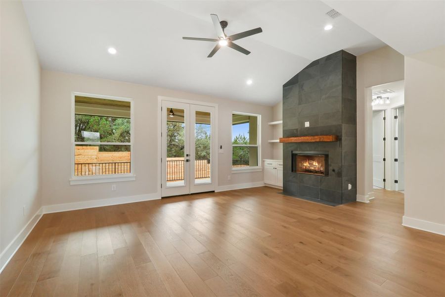 Unfurnished living room featuring ceiling fan, baseboards, light wood-style floors, and a healthy amount of sunlight Unfurnished living room featuring ceiling fan, baseboards, light wood-style floors, and a healthy amount of sunlight