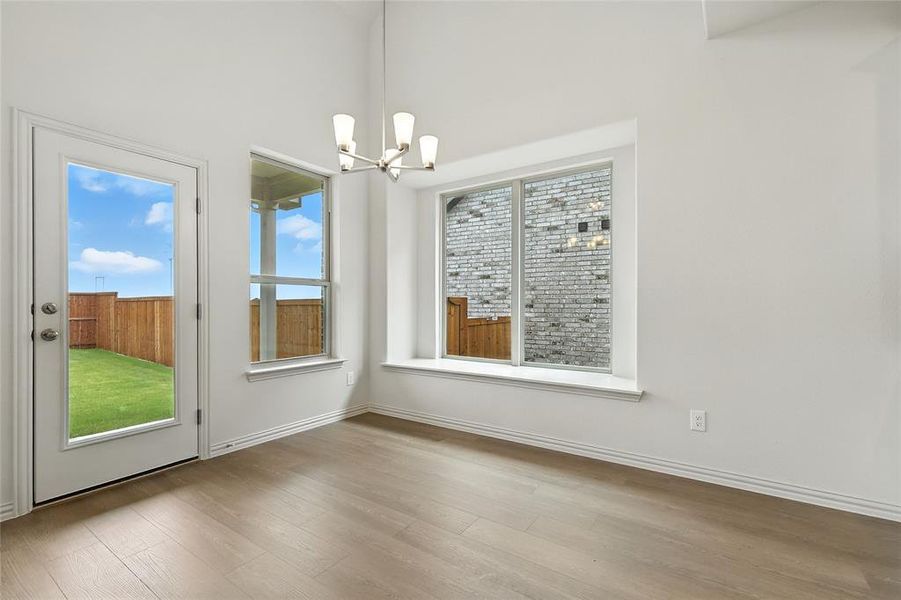 Unfurnished dining area featuring wood finished floors and a chandelier