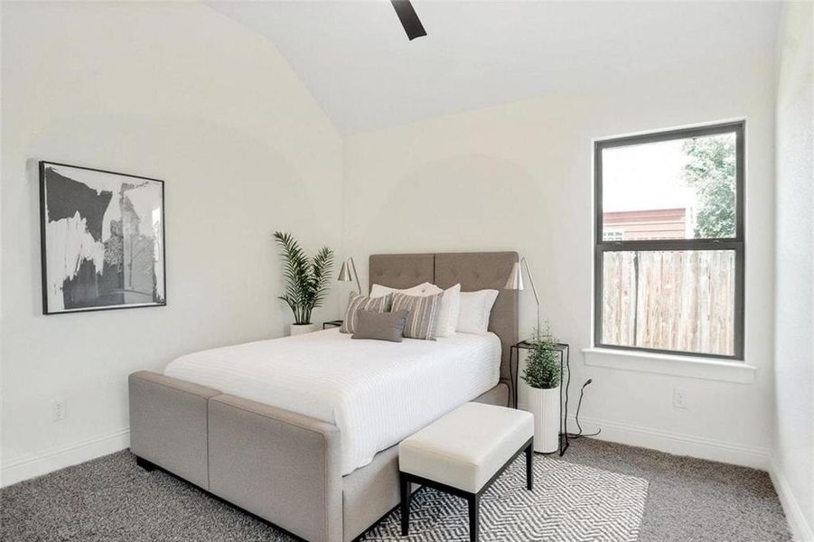 Carpeted bedroom with lofted ceiling and a ceiling fan