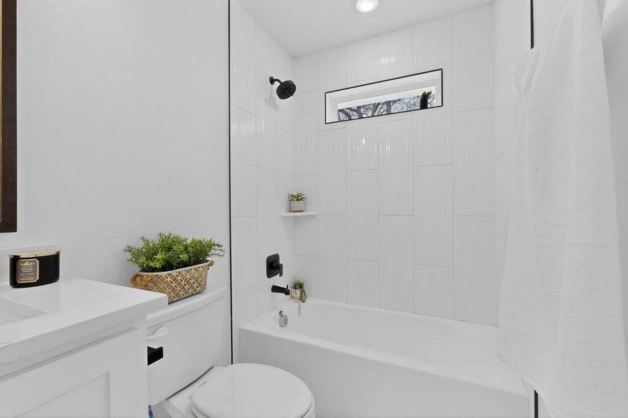 Hall bathroom featuring vanity and shower / bathtub combination with curtain Hall bathroom featuring vanity and shower / bathtub combination with curtain