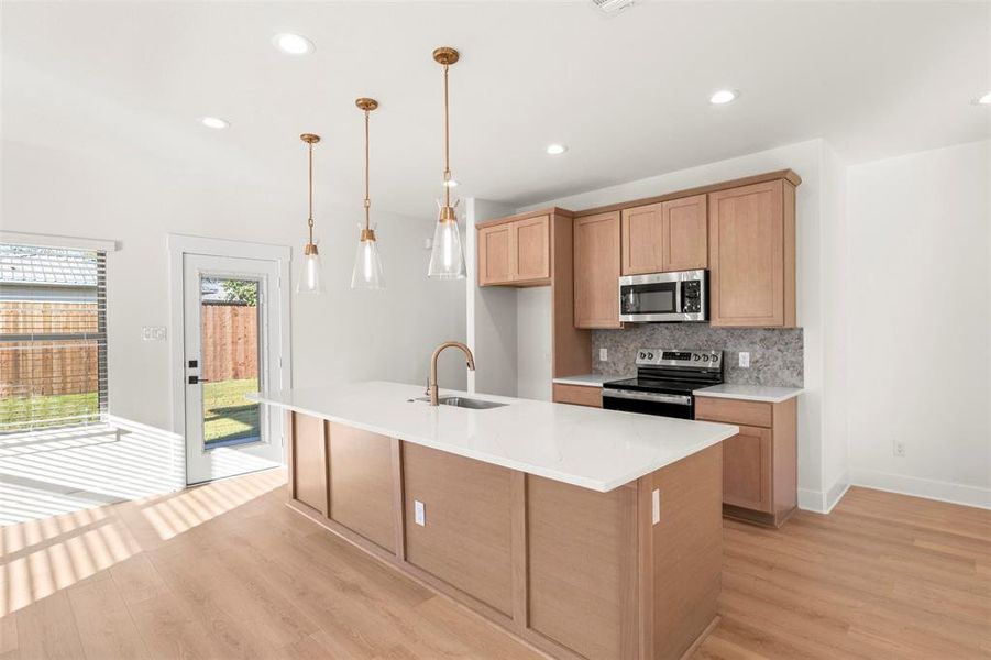 Kitchen with decorative backsplash, appliances with stainless steel finishes, recessed lighting, light wood-type flooring, and hanging light fixtures