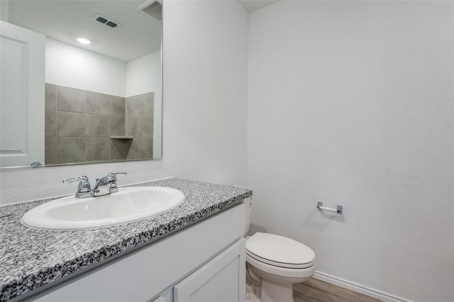 Bathroom with toilet, vanity, and hardwood / wood-style flooring