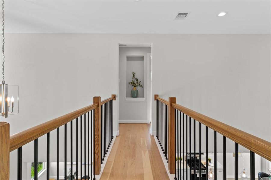 Beautiful second-floor hallway with an open-to-below design, offering a stunning view of the main living area and enhancing the home's airy, connected feel.