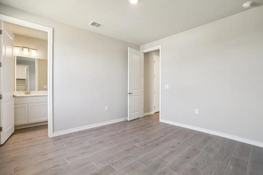 Unfurnished bedroom with wood tiled floors, connected bathroom, and recessed lighting