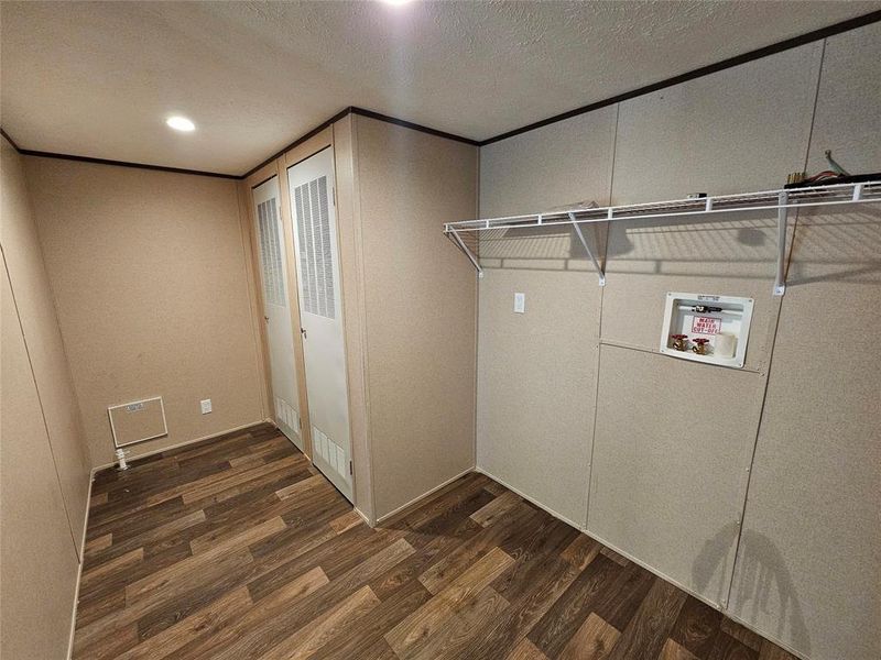 Laundry room with dark wood-style floors, a textured ceiling, hookup for a washing machine, recessed lighting, and ornamental molding Laundry room with dark wood-style floors, a textured ceiling, hookup for a washing machine, recessed lighting, and ornamental molding