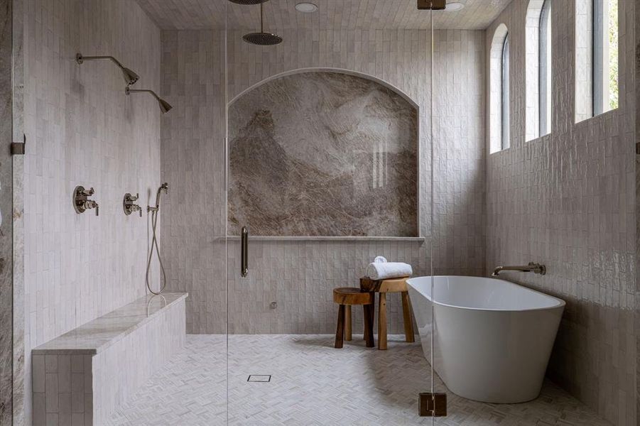 Bathroom featuring tile walls, a stall shower, and a soaking tub