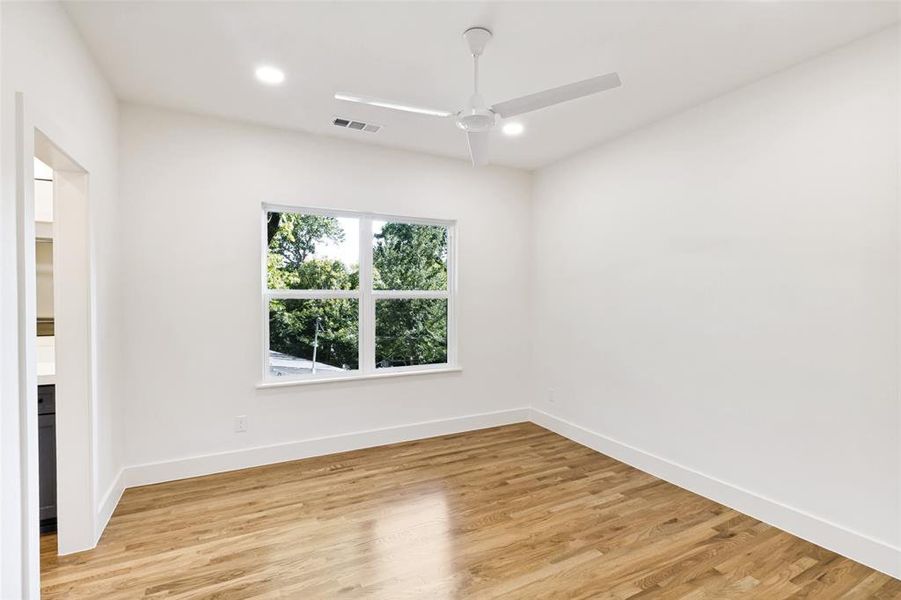 Room featuring wood-finish flooring, a contemporary ceiling fan, and recessed lighting Room featuring wood-finish flooring, a contemporary ceiling fan, and recessed lighting