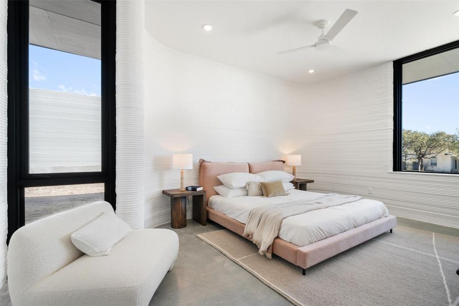 Bedroom featuring ceiling fan and concrete floors