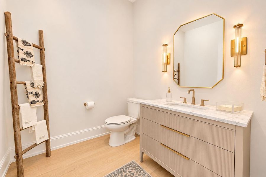 Stylish powder room featuring a sleek vanity, contemporary fixtures, designer mirror, and warm modern finishes. Thoughtful details create a polished and welcoming space for guests. Stylish powder room featuring a sleek vanity, contemporary fixtures, designer mirror, and warm modern finishes. Thoughtful details create a polished and welcoming space for guests.