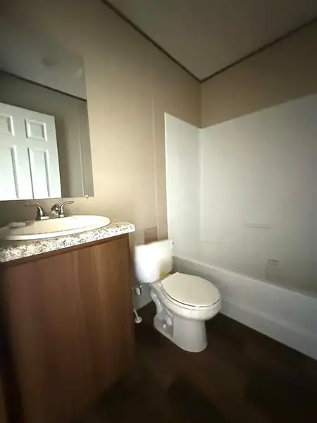 Bathroom featuring a white bathtub, toilet, and a vanity with a white basin sink Bathroom featuring a white bathtub, toilet, and a vanity with a white basin sink