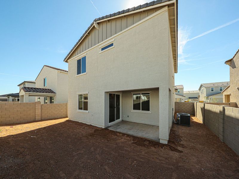 A white building with a dirt yard. A white building with a dirt yard.
