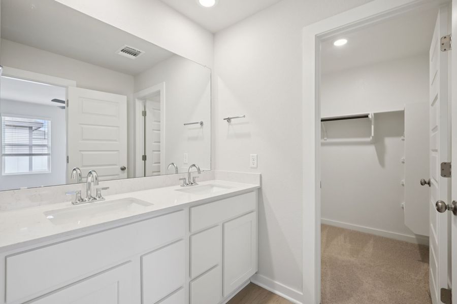 A bathroom with white cabinets.