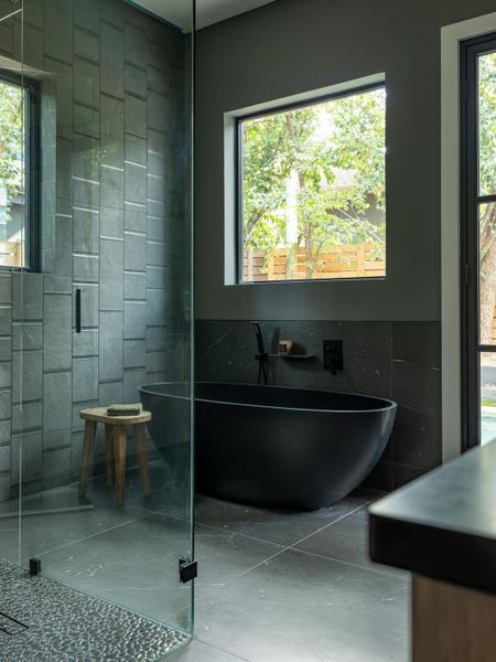 Full bath featuring a freestanding bath, healthy amount of natural light, tile walls