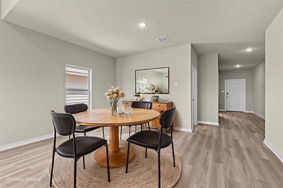 A welcoming dining area boasts modern design and seamless connectivity to the main entry.