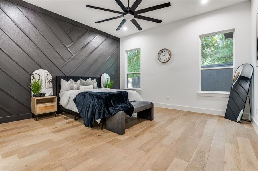 Bedroom with light wood-style flooring, multiple windows, ceiling fan, an accent wall, and recessed lighting Bedroom with light wood-style flooring, multiple windows, ceiling fan, an accent wall, and recessed lighting