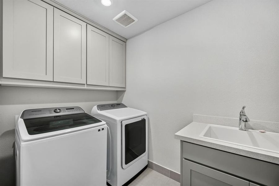Second floor laundry room featuring light gray cabinetry, a built-in sink with a single-handle faucet, and tile flooring