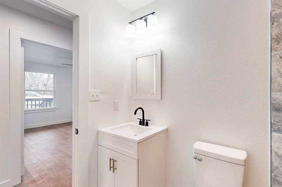 Bathroom featuring vanity, wood-type flooring, and toilet