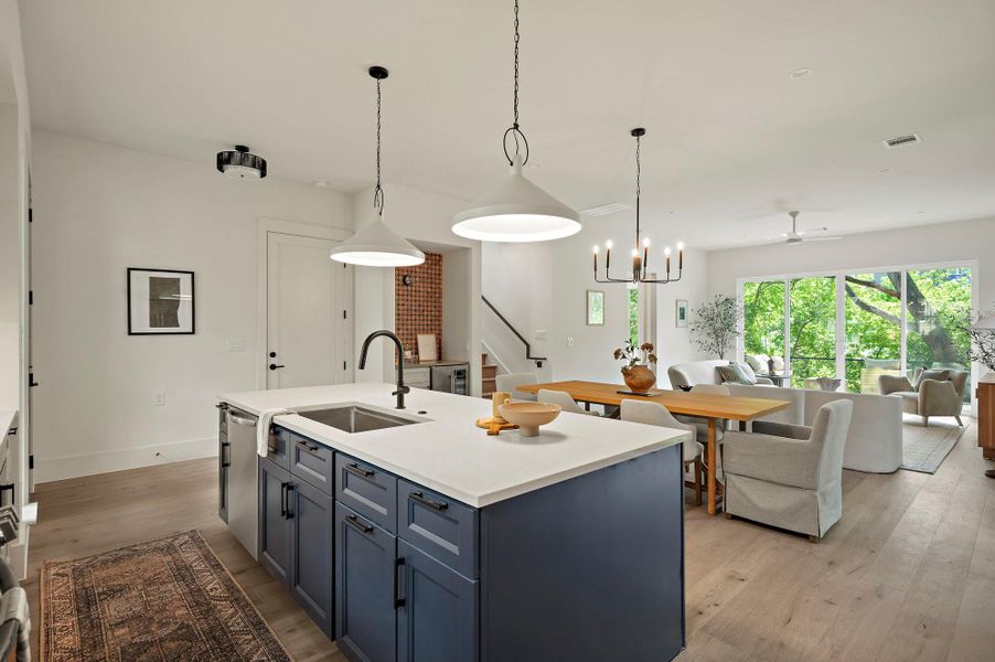 Kitchen with dishwasher, open floor plan, a sink, light wood-type flooring, and a ceiling fan