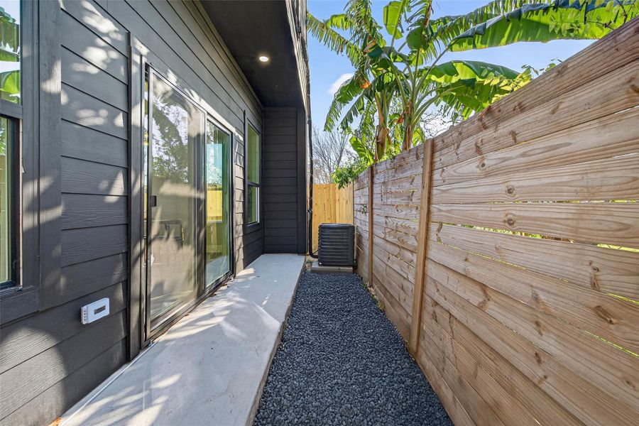 Private outdoor yard with sliding glass door access full wood privacy fencing—ideal for pets, morning coffee, or seamless indoor-outdoor living.