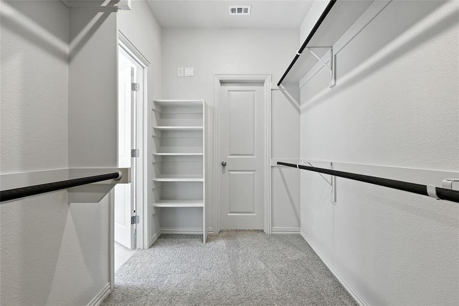 Spacious closet with light colored carpet