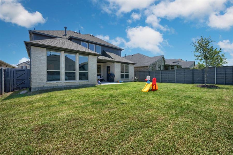 Back of property featuring a patio area and a lawn