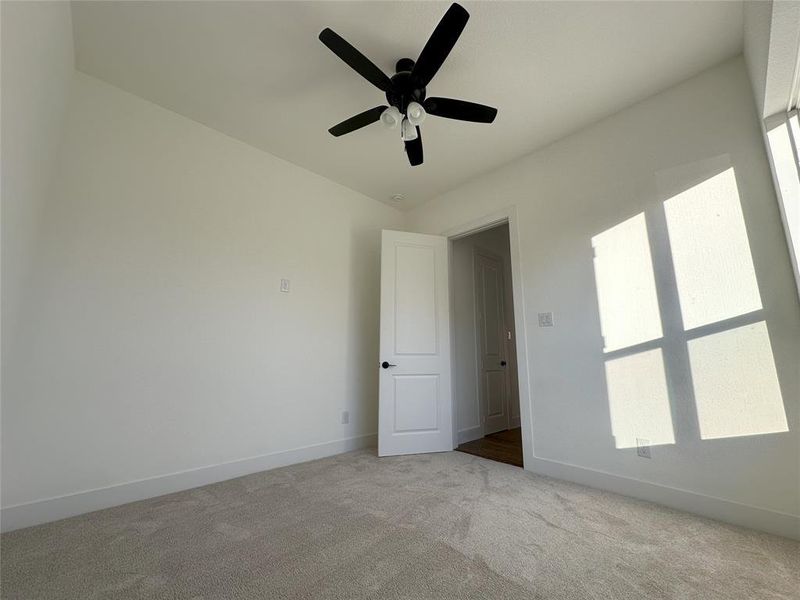 Unfurnished room featuring ceiling fan and light colored carpet