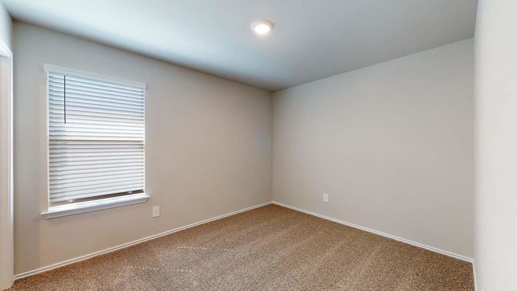 Carpeted interior room featuring a single window with blinds, recessed ceiling lighting, light-toned walls, and white baseboards