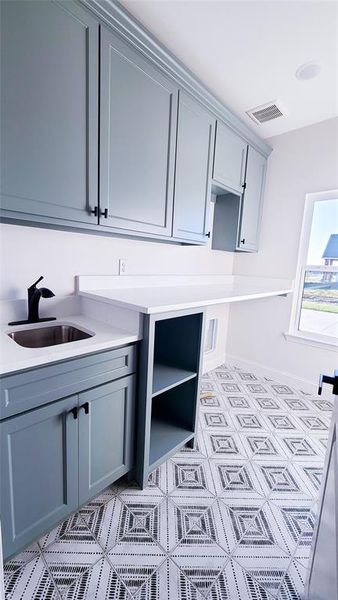 Laundry room with sink and cabinets