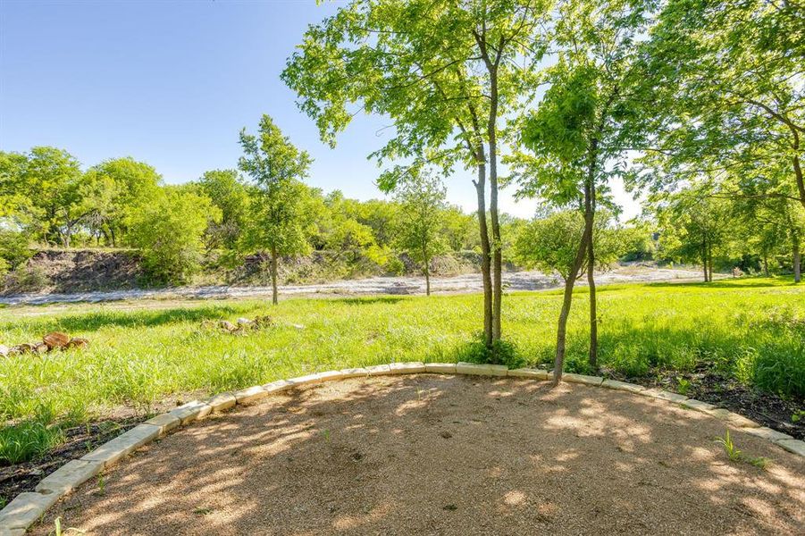 View of yard that back up to Bear Creek and fire pit area