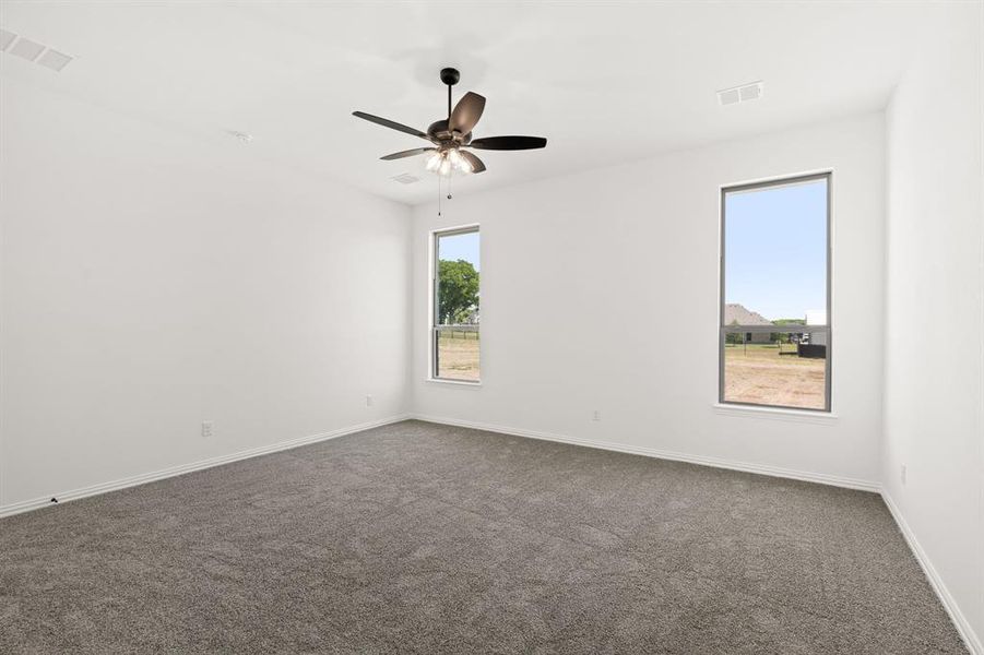 Empty room with dark colored carpet and ceiling fan Empty room with dark colored carpet and ceiling fan