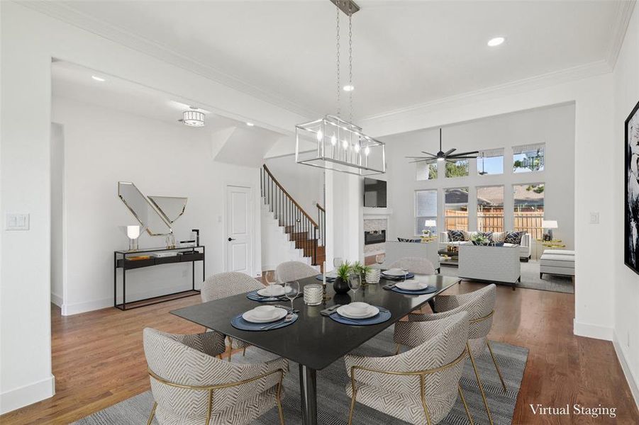 Dining space featuring a fireplace, ornamental molding, recessed lighting, wood finished floors, and ceiling fan