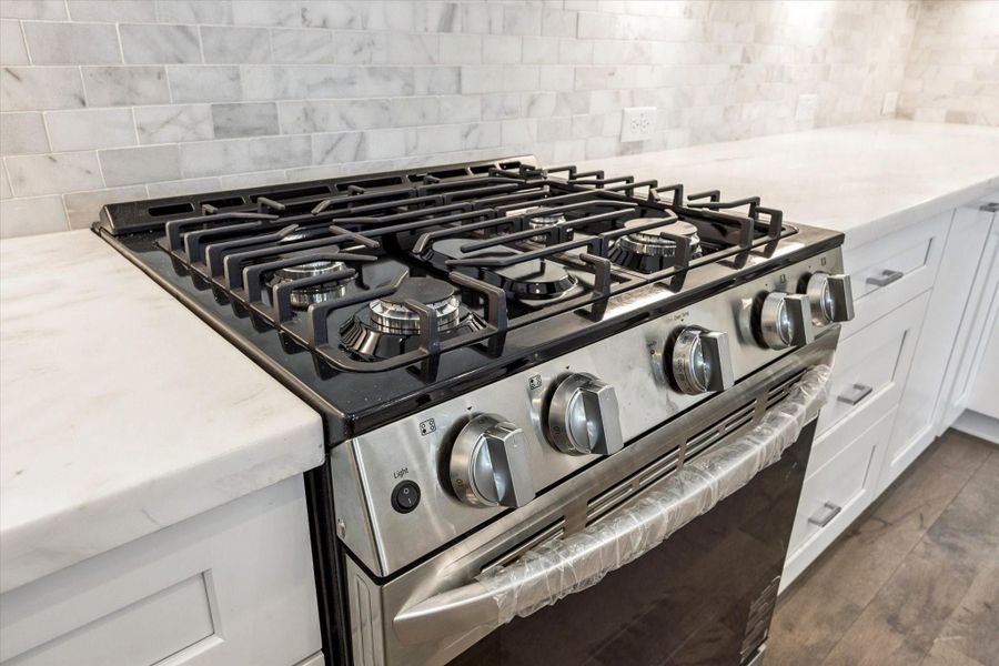 Stainless Steel Gas Stove * Marble Backsplash * Under Cabinet Lighting. Stainless Steel Gas Stove * Marble Backsplash * Under Cabinet Lighting.